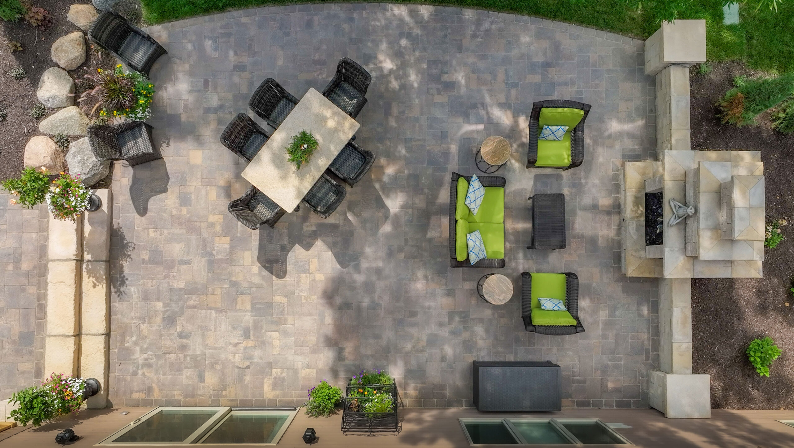 Aerial view of a paver patio with seating area and outdoor fireplace